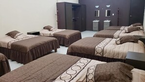 A hotel room with four beds, a wardrobe, a vanity with two sinks, and a mirror. - Gran Hotel Alijadores (Tampico)