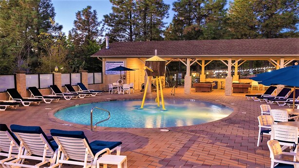 A pool area with lounge chairs and a covered seating area. - 1Bed/1Bath - Gorgeous Flagstaff with Pools, Golf, and More! (Flagstaff)