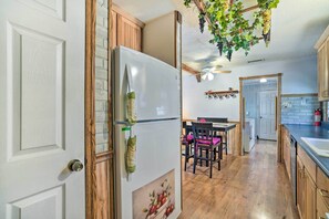 Enjoy cooking in this well-equipped kitchen with a central island, wooden cabinetry, and a dining area nearby.
