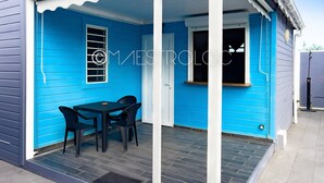 Een laag, eenlaags gebouw met een blauwe gevel en een overdekte veranda.