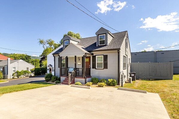 A single-story house with a front porch, a garage, and a fenced backyard. - Altavista House - Renovated, Charming, & Walkable (Charlottesville)