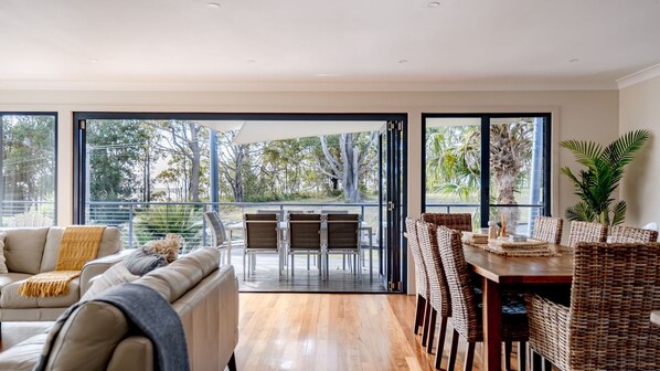 Relax in this stylish living area with a sofa, dining table, and balcony access.