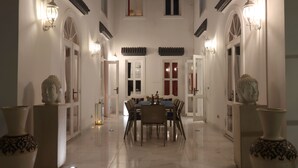 A spacious dining area with a long table, chairs, and decorative vases. - Riad VIP (Marrakech)