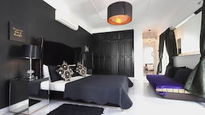 A modern bedroom with a large bed, a bedside table, a black rug, and a ceiling light fixture. - Riad VIP (Marrakech)
