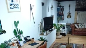 Un saló acollidor amb una taula baixa de fusta, una televisió i un sofà vermell.