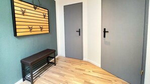 A hallway with a wooden bench, a wall-mounted deer head decoration, and two grey doors. - Hirschtraum im Zentrum von Braunlage (Braunlage)