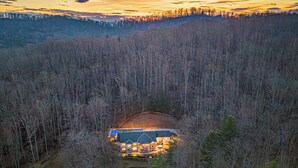 A remote lodge with a central building surrounded by dense forest, accessible by a dirt road. - 7k SqFt Estate - Epic Amenities & Fun - Sleeps 20 (Biltmore Forest)