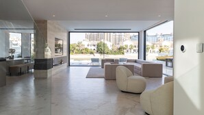Un salón amplio con un ventanal grande, un conjunto de sofás modernos y un diseño minimalista.