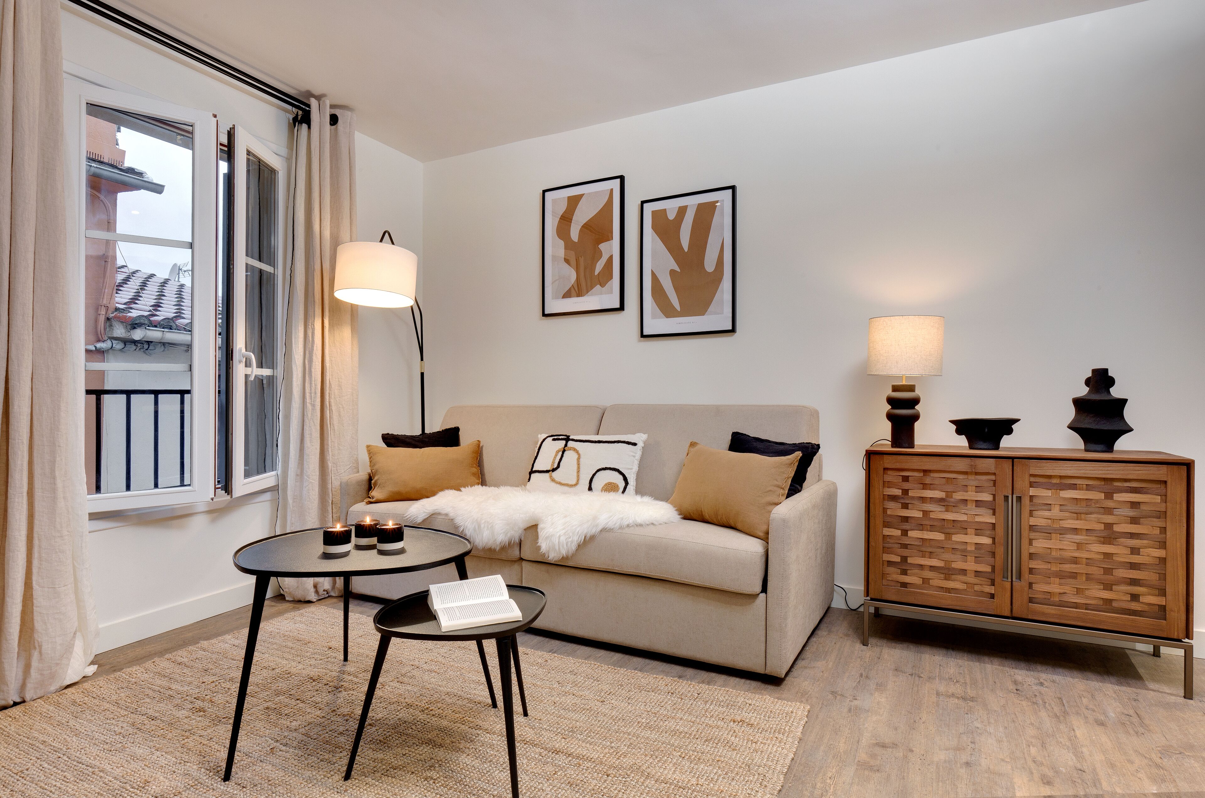 Een moderne woonkamer met een bank, een salontafel, een kast en twee wandlampen.