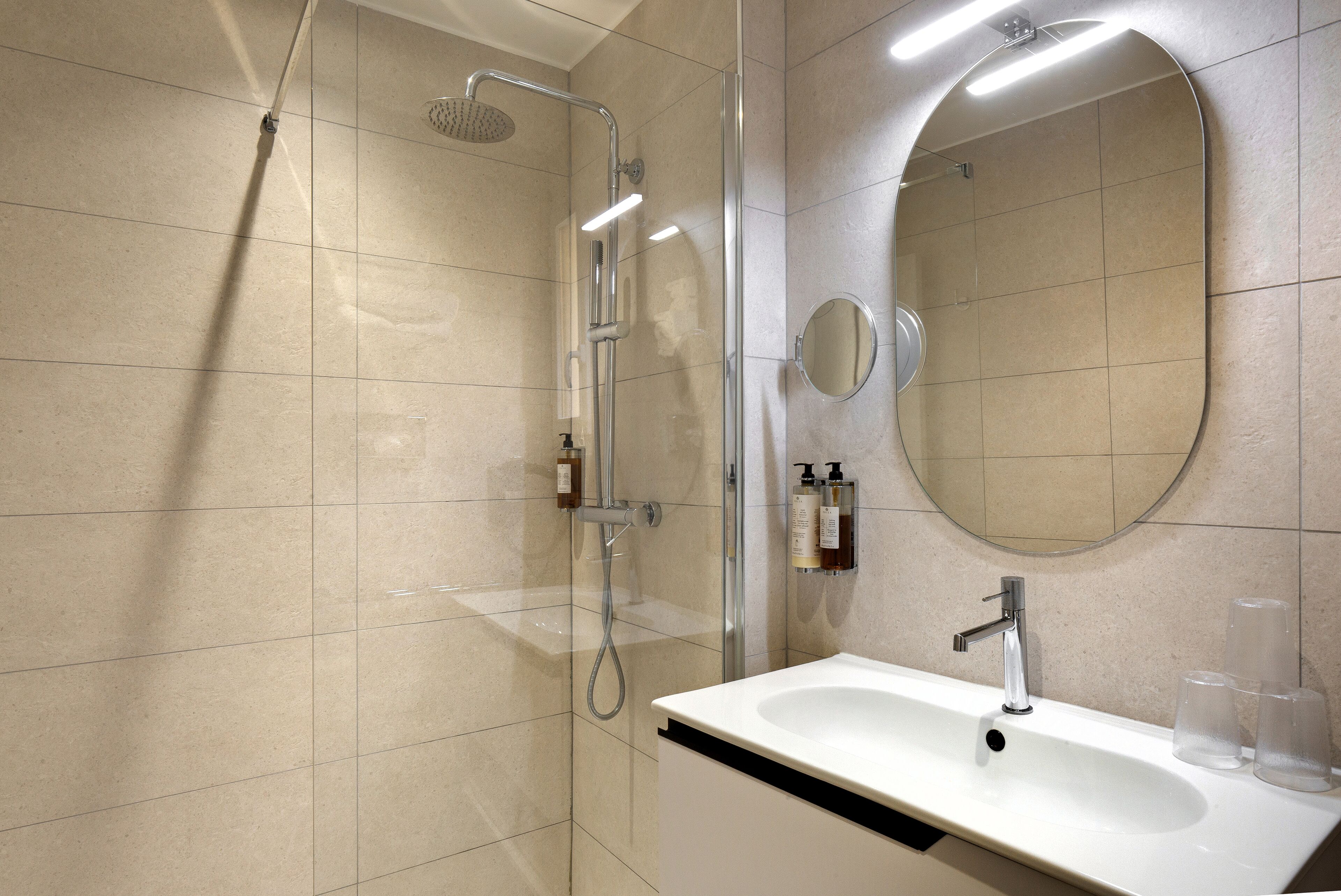 Un baño moderno con ducha, lavabo y espejo.