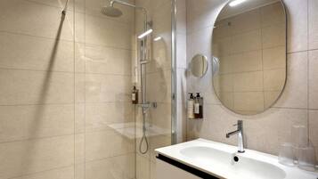 Un baño moderno con ducha, lavabo y espejo.