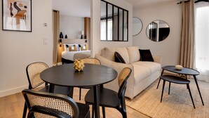 Una sala de estar moderna con una mesa de comedor redonda, dos sofás y una mesita auxiliar.