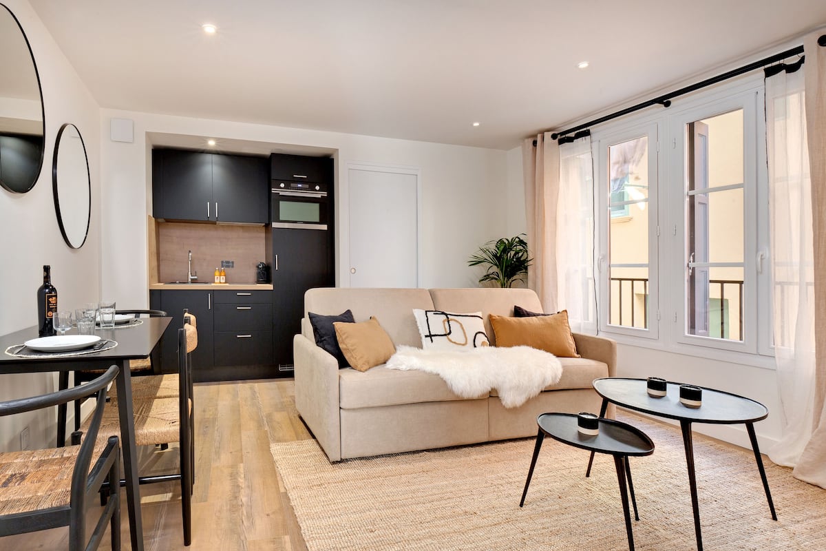 A modern living room with a sofa, coffee table, and dining area.