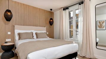Un dormitorio con una cama grande, paneles de madera en la pared, una ventana con cortinas y un espejo.