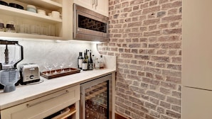Eine Küche mit Backsteinwand, integriertem Mikrowellenherd und einem Weinkühlschrank.