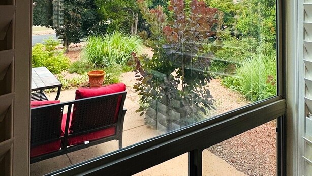 A view from a window with a patio area, including a table and chairs, and a variety of trees and shrubs. - Red Rock Views, Hot Tub, Community Pool, Walk To Pickleball Court, Trail Pass (Sedona)