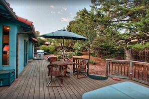 A wooden deck with outdoor furniture, a grill, and a large umbrella. - Walk to Trails, Private Hot Tub, Red Rock Views, 3BR with 2 Kings, Sunset Deck (Sedona)