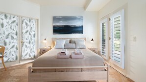 A bedroom with a bed, two bedside tables, a nightstand, a painting, and a view through the window. - Red Rock Views, Hot Tub, Community Pool, Walk To Pickleball Court, Trail Pass (Sedona)