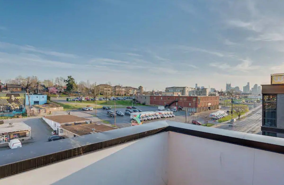 A view of a parking lot with several cars and a building in the background.