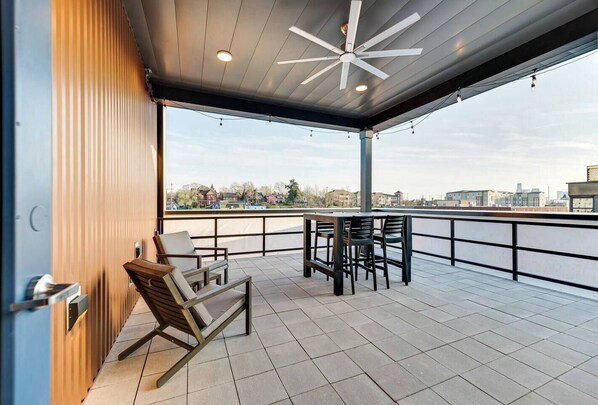 Relax on the outdoor terrace with a wooden rocking chair and bar stools, taking in the views of the surrounding water and cityscape.