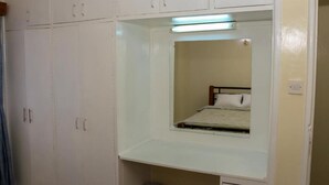A bedroom with a bed, a mirror, and a wardrobe. - HAZINA ESTATE SOUTH B (Nairobi)