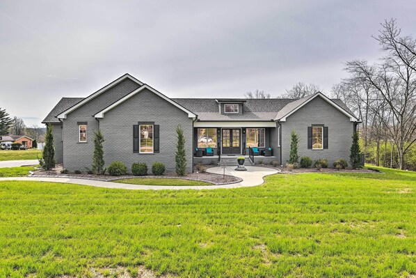 A two-story house with a grey exterior, a front porch with seating, and a well-maintained lawn. - Beautiful Nashville Home Near Downtown w/ Hot Tub! (Nashville)