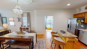 Una cocina moderna con armarios de madera, encimera de granito y refrigerador de acero inoxidable.