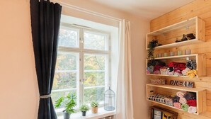 A room with a window, a radiator, and shelves with folded clothes and a 'DREAM' sign. - HAPPY HOME HELSINKI-KALLIO (Helsinki)