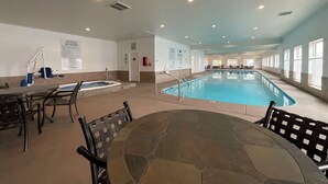 En inomhuspool med bubbelbad, sittområde och regler för användningen av spa-anläggningen, som är uppsatta på väggarna.