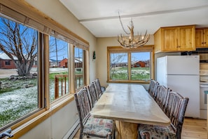 A dining area with a large table and chairs, wooden cabinets, and a chandelier. - Hiker - Rare gem in an outdoorsman's paradise (Clark)