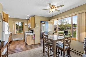 A kitchen with a dining area, a ceiling fan, and a view of the outdoors. - Homesteader - Peaceful cabin with beautiful views (Clark)