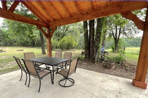 Relax in a serene natural setting surrounded by trees and a grassy field.