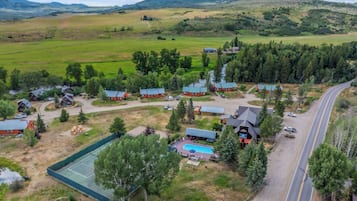 Une propriété rurale comprenant plusieurs chalets, une piscine et un chemin.