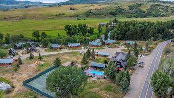 Une propriété rurale comprenant plusieurs chalets, une piscine et un chemin.