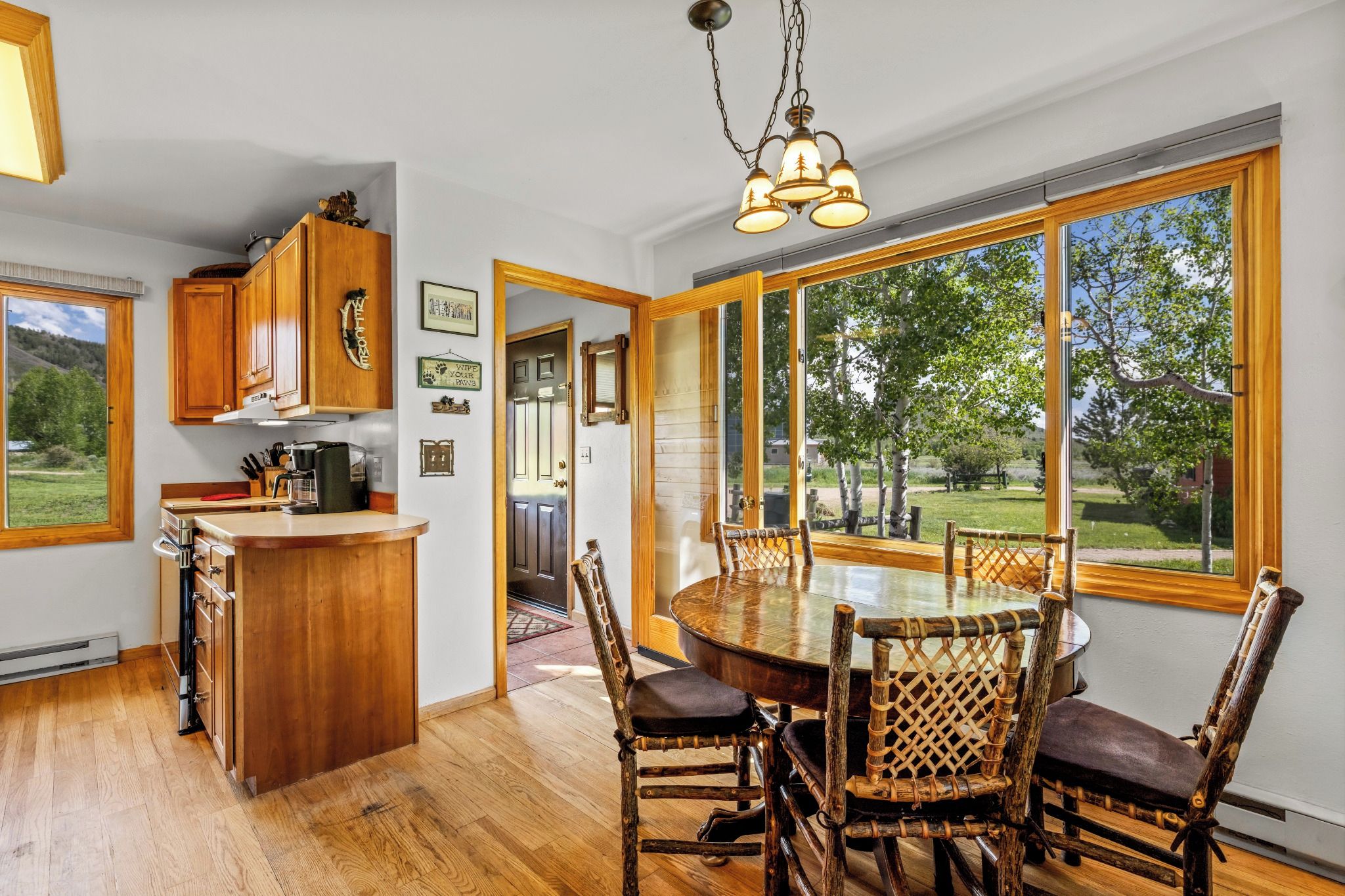 A kitchen with wooden cabinets, a bar area, and a dining table with chairs.
