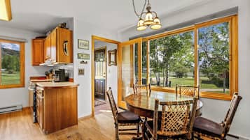 A kitchen with wooden cabinets, a bar area, and a dining table with chairs.