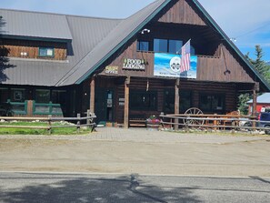Un bâtiment rustique en bois, sur lequel on peut lire les inscriptions « Restauration et hébergement » et « Bureau du complexe Glen Eden ».