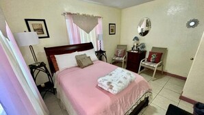 A bedroom with a bed, bedside tables, a chair, and a mirror. - Comfortable Home in Hallandale Beach (Hallandale beach)