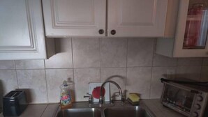 A kitchen with two sinks, a toaster, a bottle of dish soap, and a microwave. - Comfortable Home in Hallandale Beach (Hallandale beach)