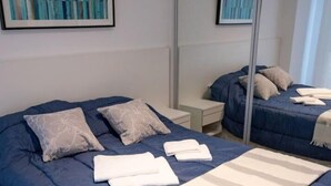 Una habitación de hotel con una cama grande, una mesita de noche, un espejo y obras de arte en la pared.