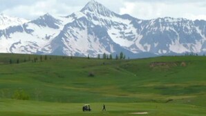 A wide, open field with a mountain range in the background.