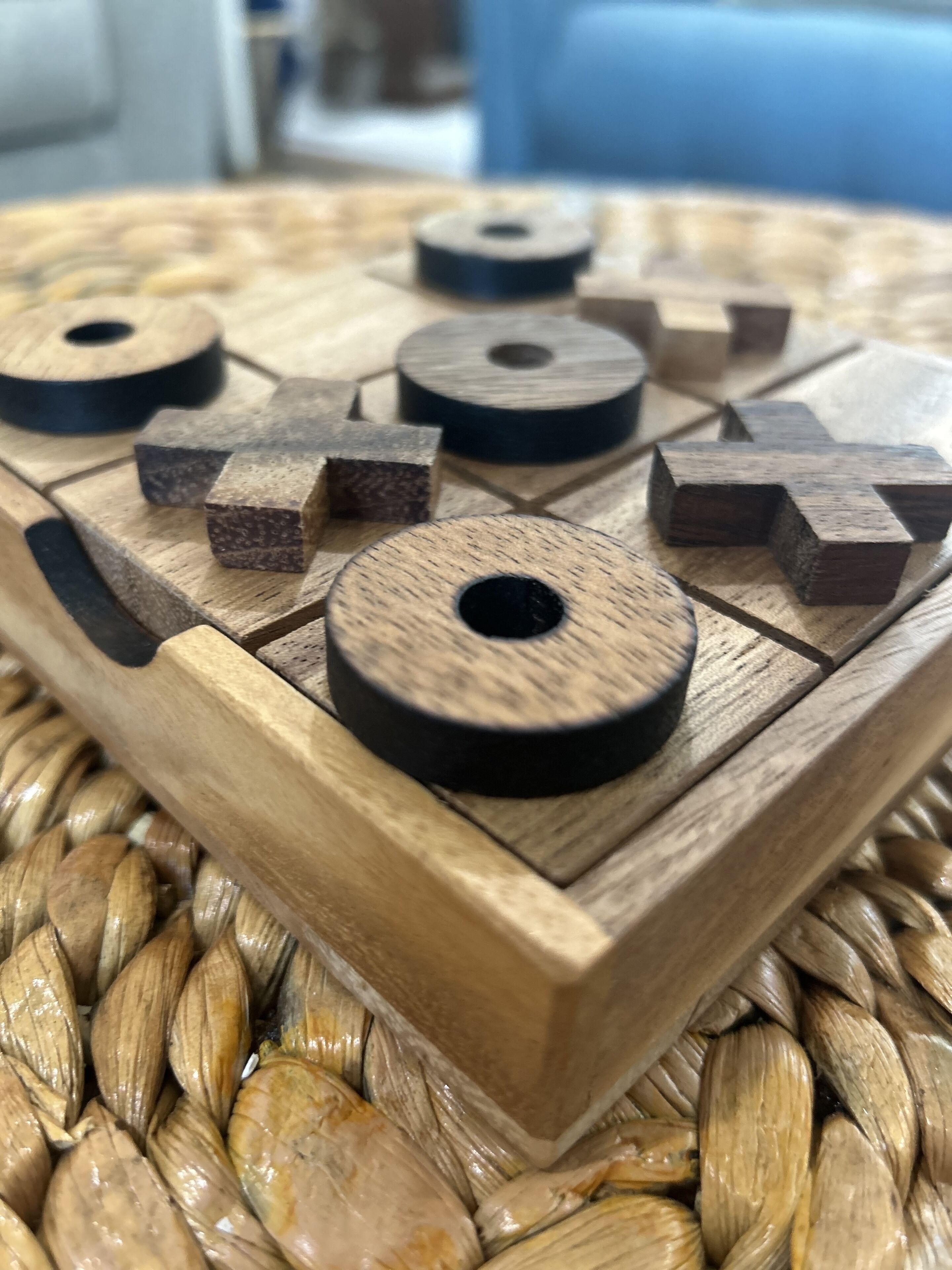 A wooden tray with geometric shapes and a woven table surface.