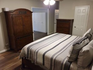 Un dormitorio con cama, cómoda y armario.
