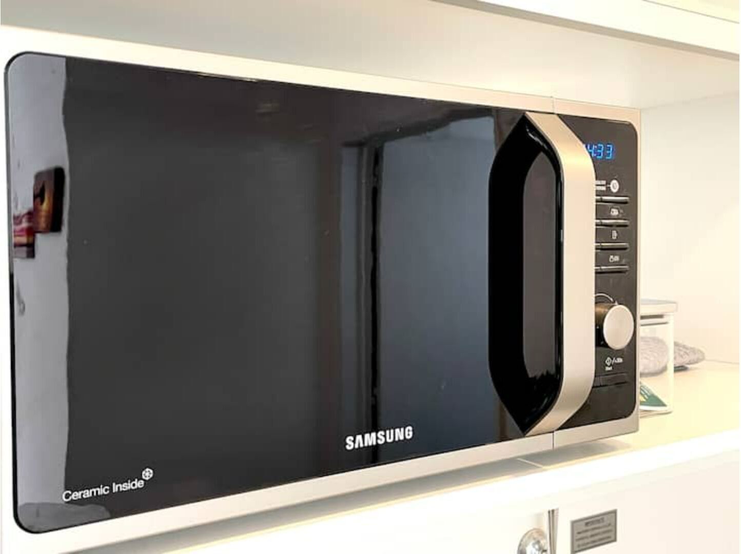 A Samsung microwave with a digital display, control buttons, and a ceramic interior.