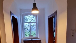 A hallway with wooden flooring, a central rug, and a hanging light fixture. - Das Alte Herrenhaus - Wohnen wie zu Kaisers Zeiten (Kevelaer)