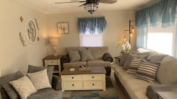 A living room with two sofas, a coffee table, and a ceiling fan. - Country View Cottage-Near Massanutten, Skyline drive,&JMU.A home away from home! (Elkton)