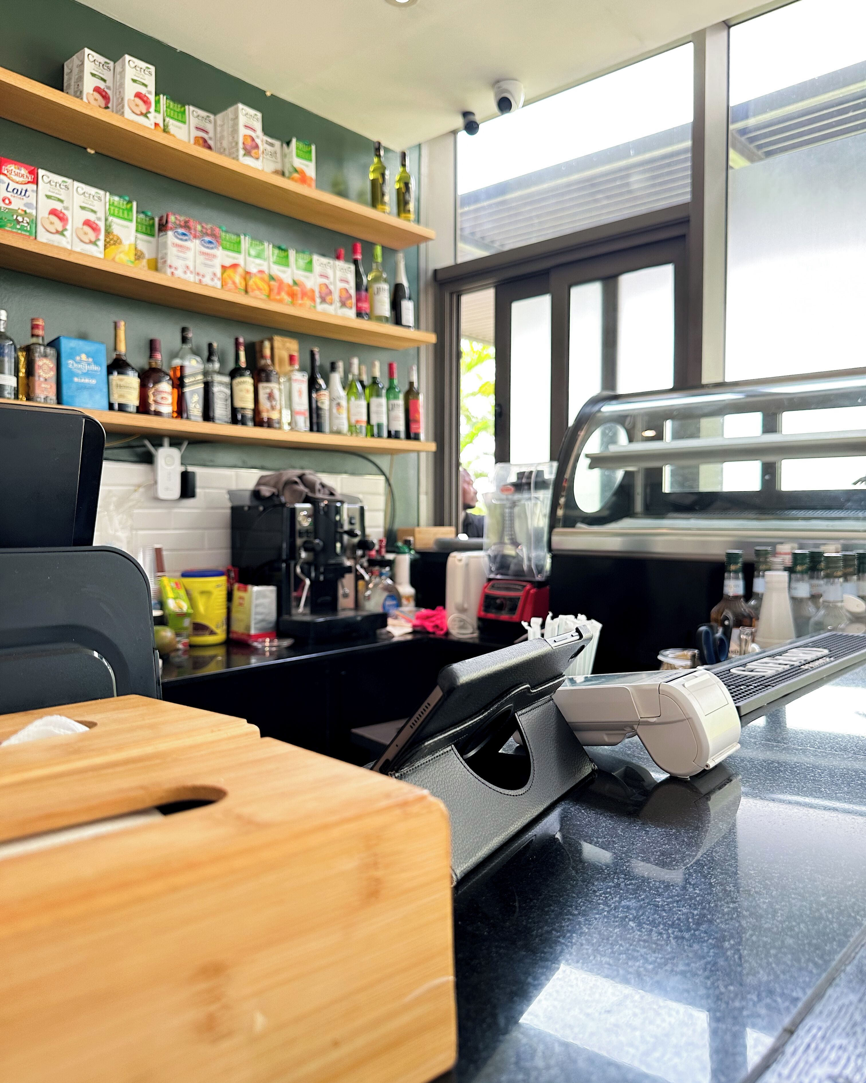 A kitchen area with shelves stocked with various food items and bottles.