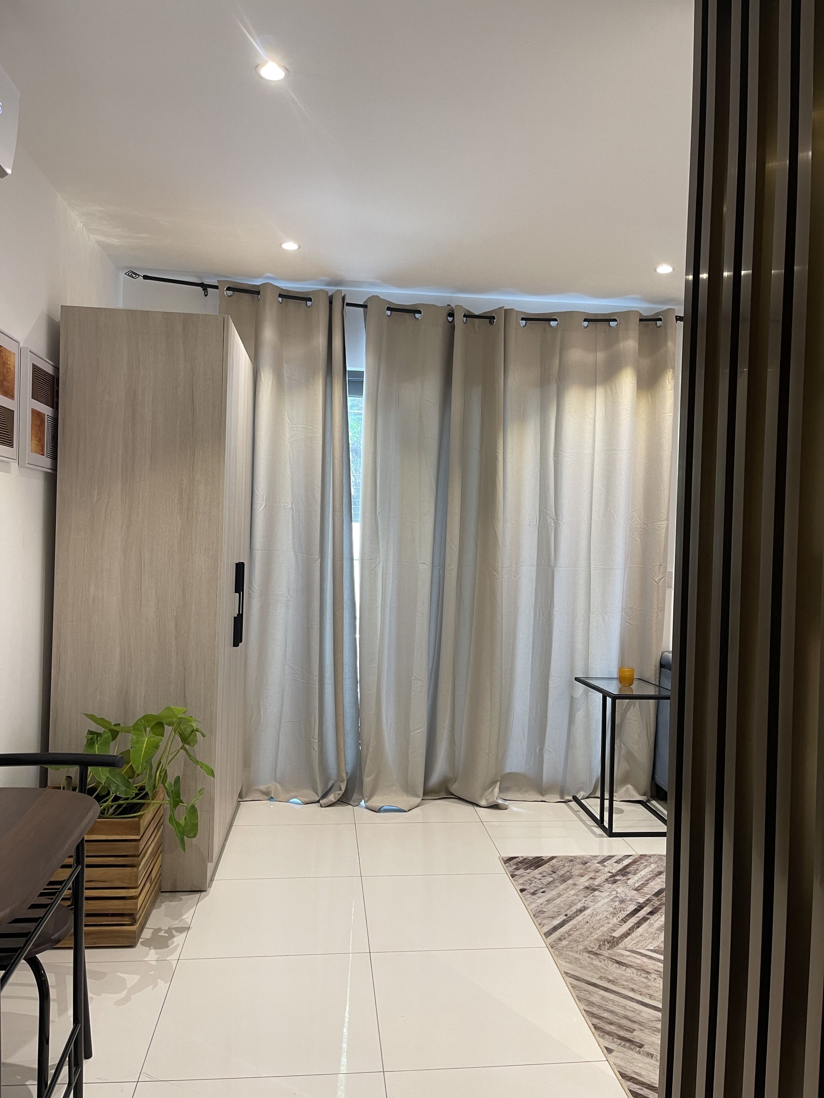 A modern room with a sliding door, a small table with a plant, and a tiled floor.