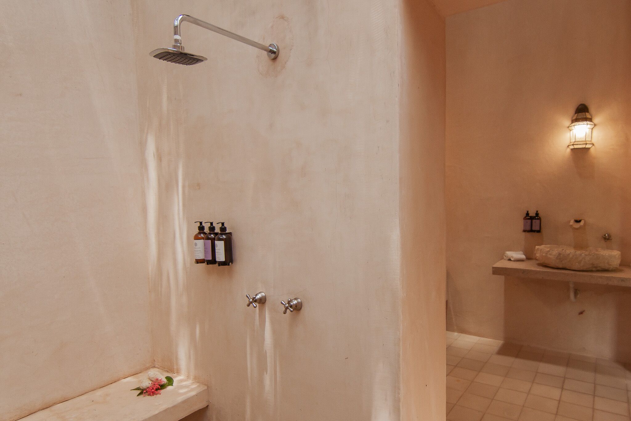 A bathroom with a shower, toilet, and sink area.