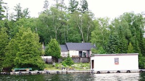 A lakeside cabin with a dock, surrounded by dense forest. - Escape to Island Paradise - Clearwater Bay, L.O.T.W. (Clearwater Bay)